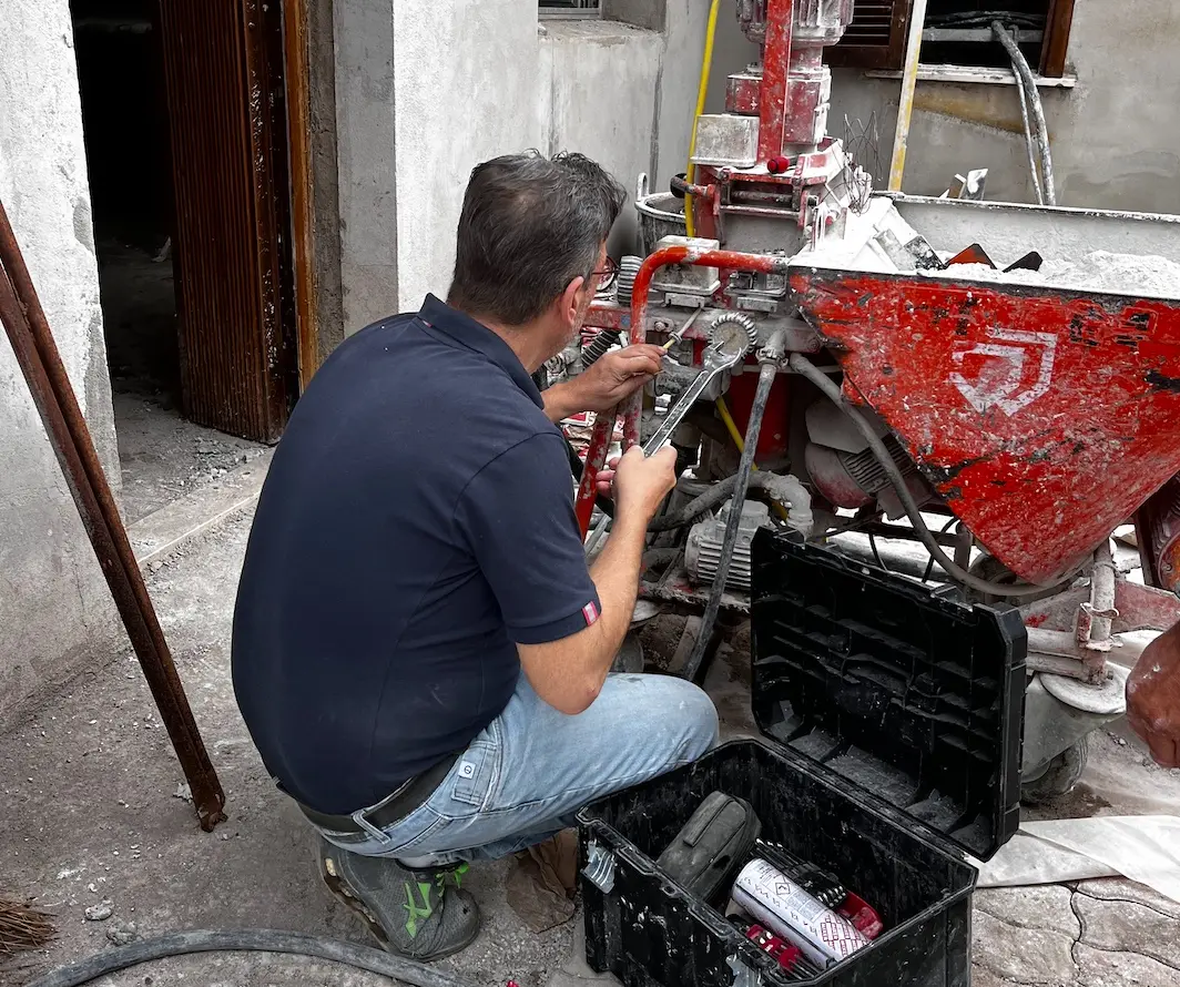 Tecnico Pace Service durante la riparazione di una macchina intonacatrice